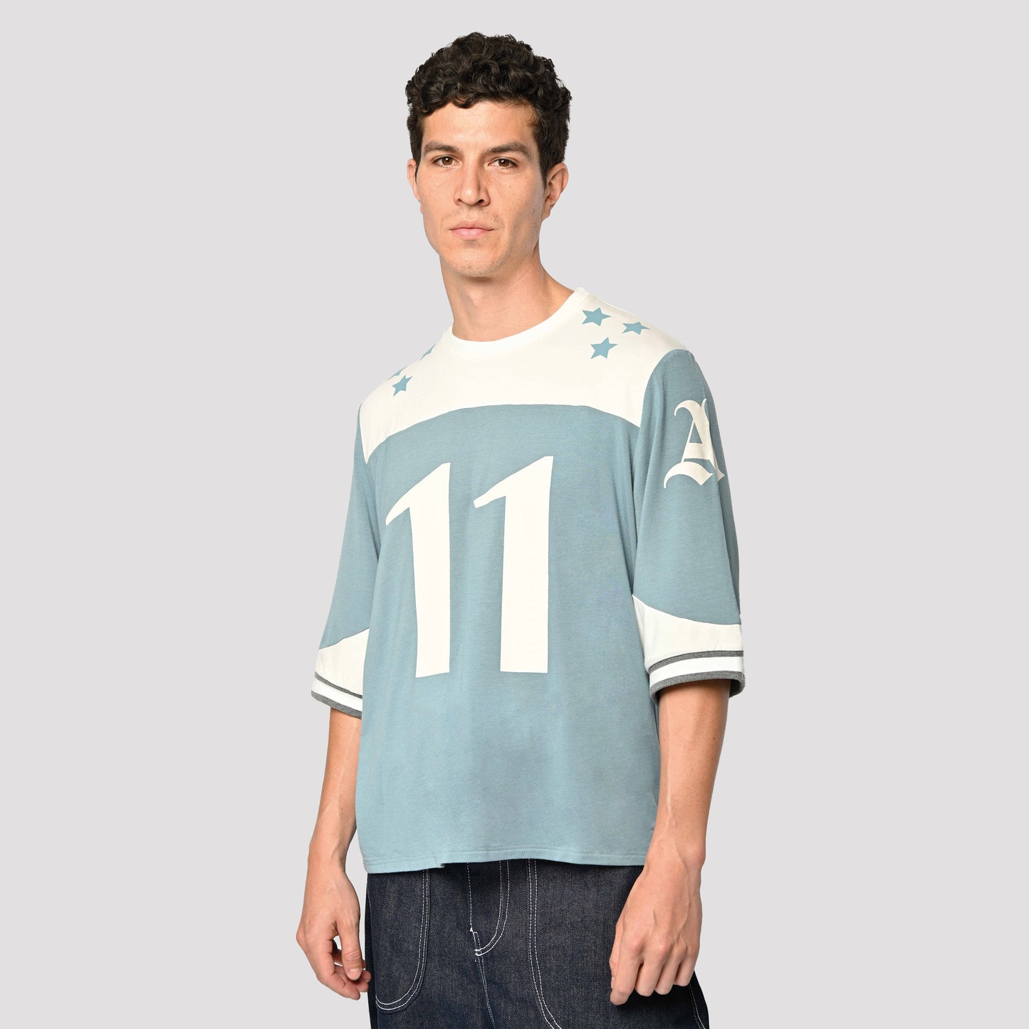 Model is wearing Taylor Football Tee by Aseye Studio in Blue