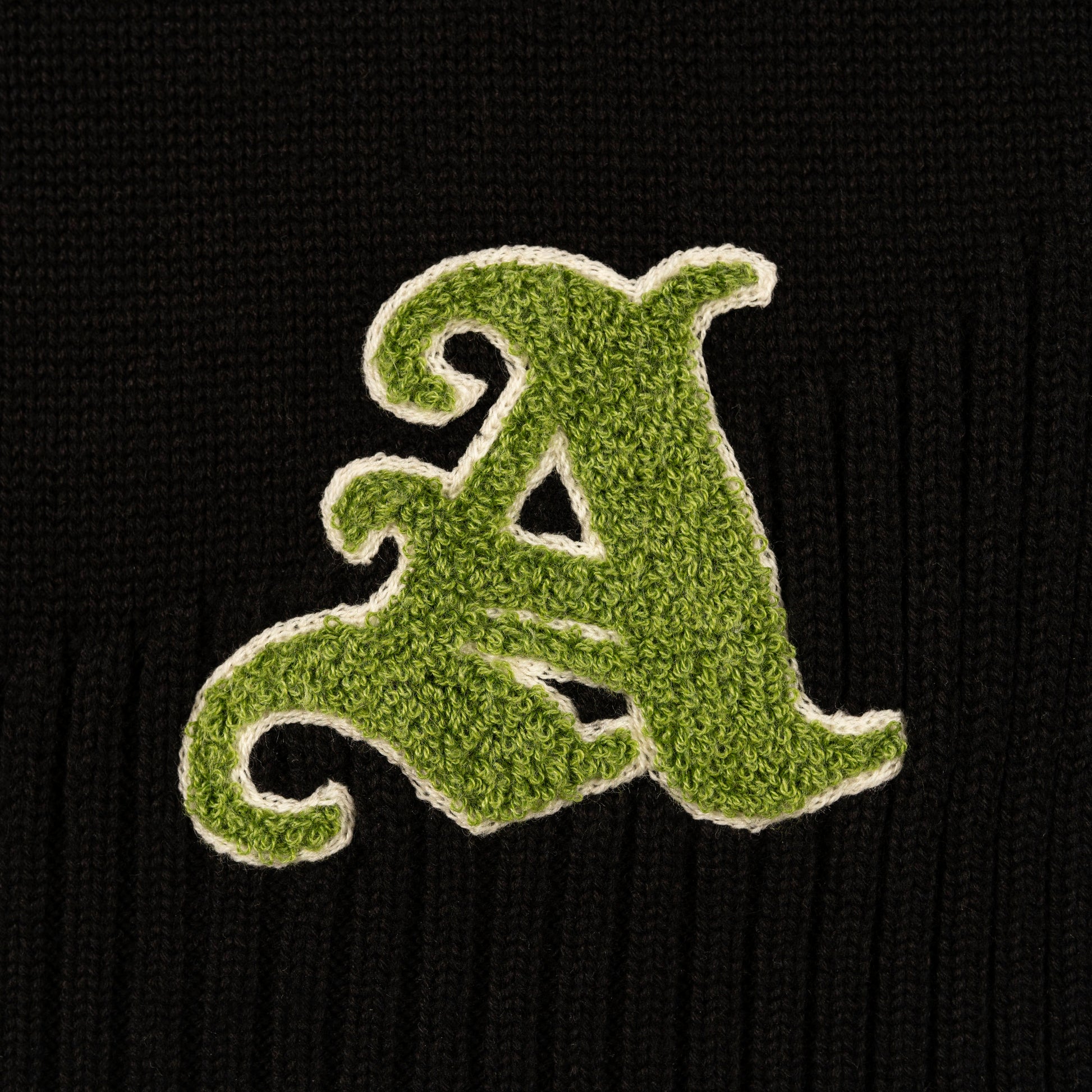 Detail view of chenille letter logo  on Kai Rugby Knit by Aseye Studio