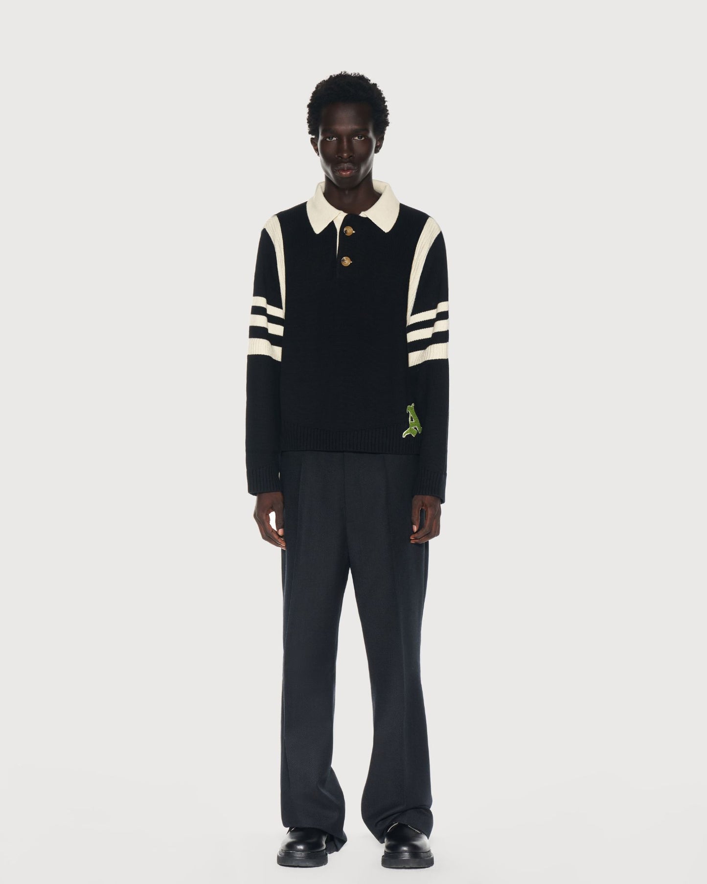 Man wearing an Aseye Studio black and cream striped sweater with a cream color collar on a white background. Shop