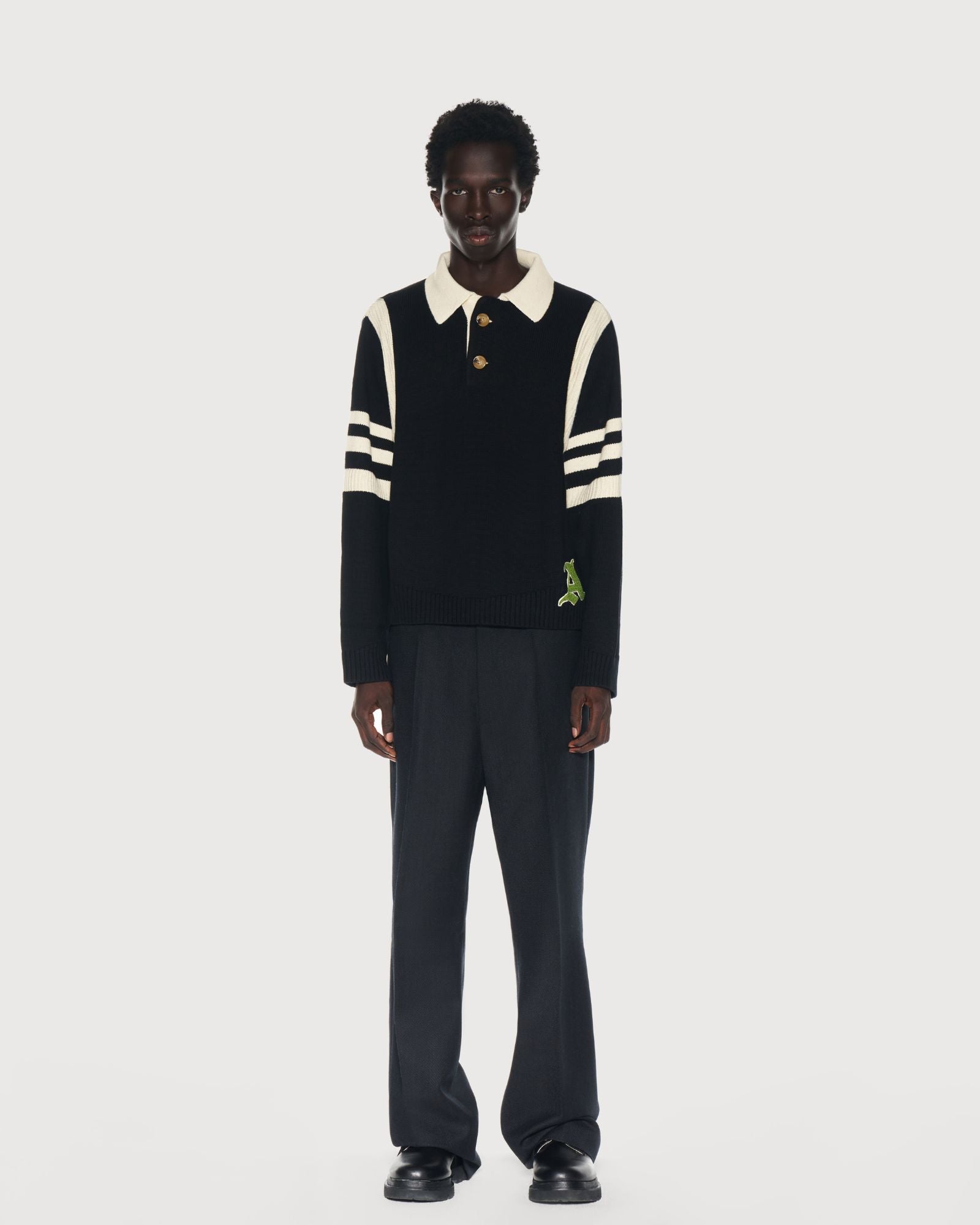 Man wearing an Aseye Studio black and cream striped sweater with a cream color collar on a white background. Shop