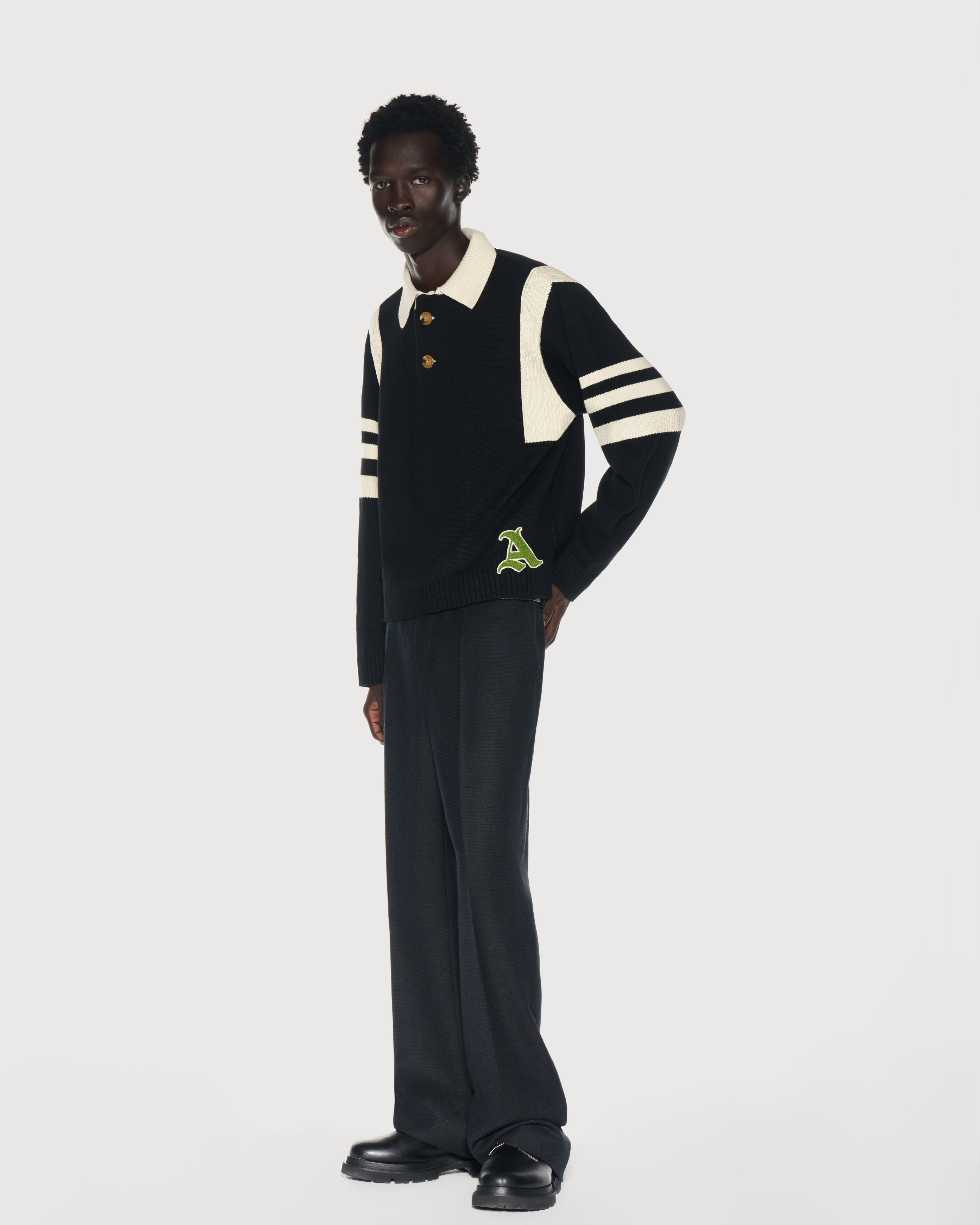 Man is wearing black knit rugby sweater with cream stripes by Aseye Studio. Offer 20% Off New Collection for Black Friday and Cyber Weekend Sale. 