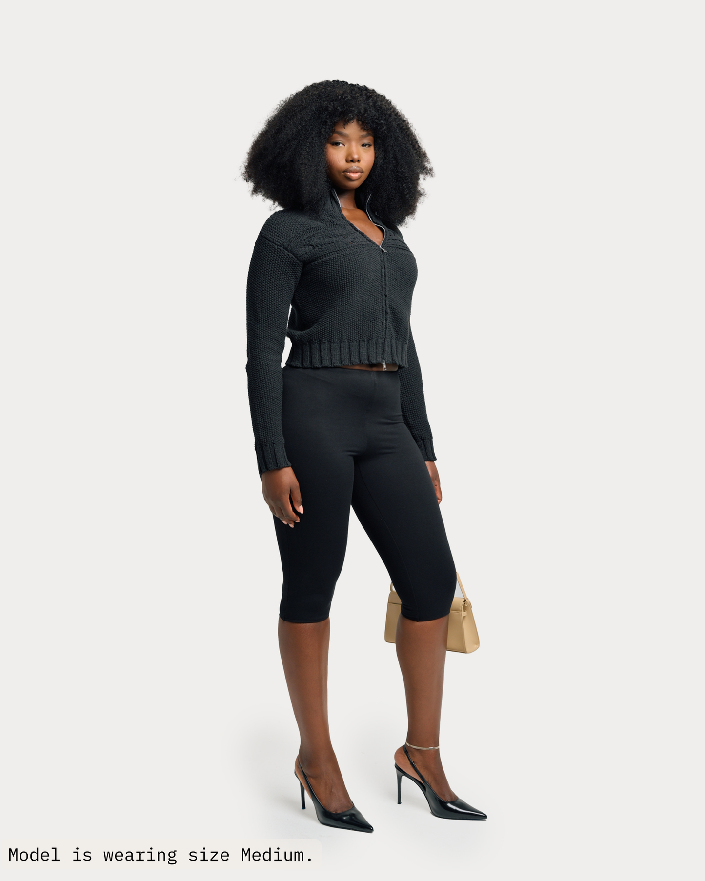 Model is wearing Tynia Zip-Up Knit Track Cardigan in size medium and black colorway. 