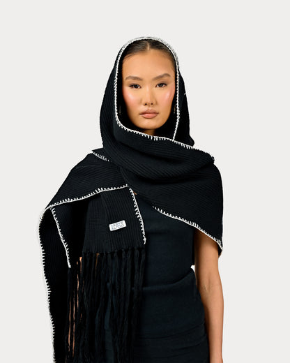 Model is wearing heavy knit Yuki Scarf by Aseye Studio in Black with white piping.