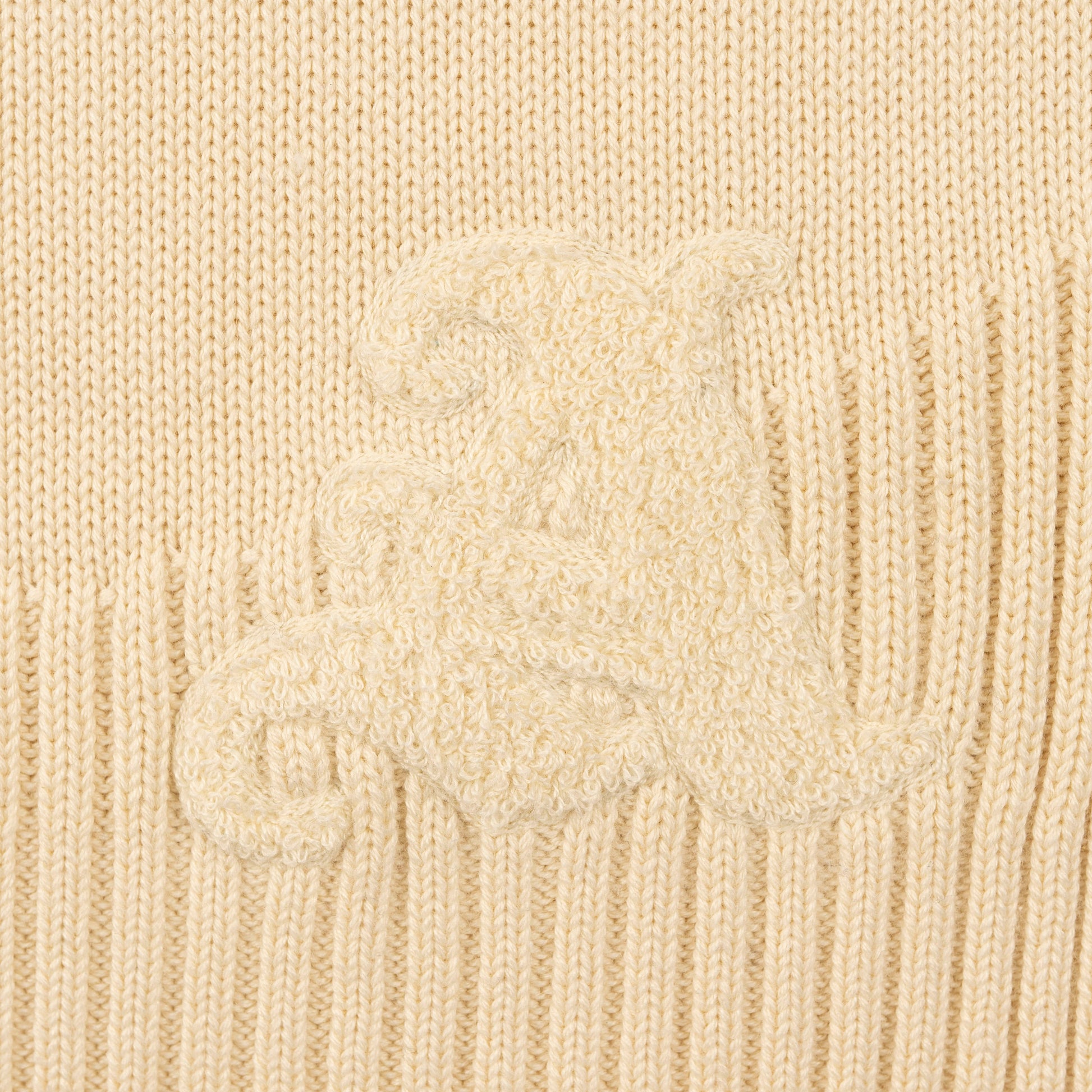 Detail View of Chenille Signature 'A' Logo and Curved Ribbed hem on Kai Rugby Knit Sweater by Aseye Studio