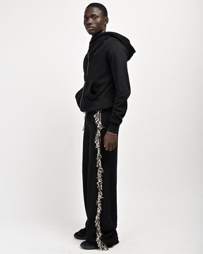 Side View of Model wearing Andy Fringe Knit Pants in Black by Aseye Studio