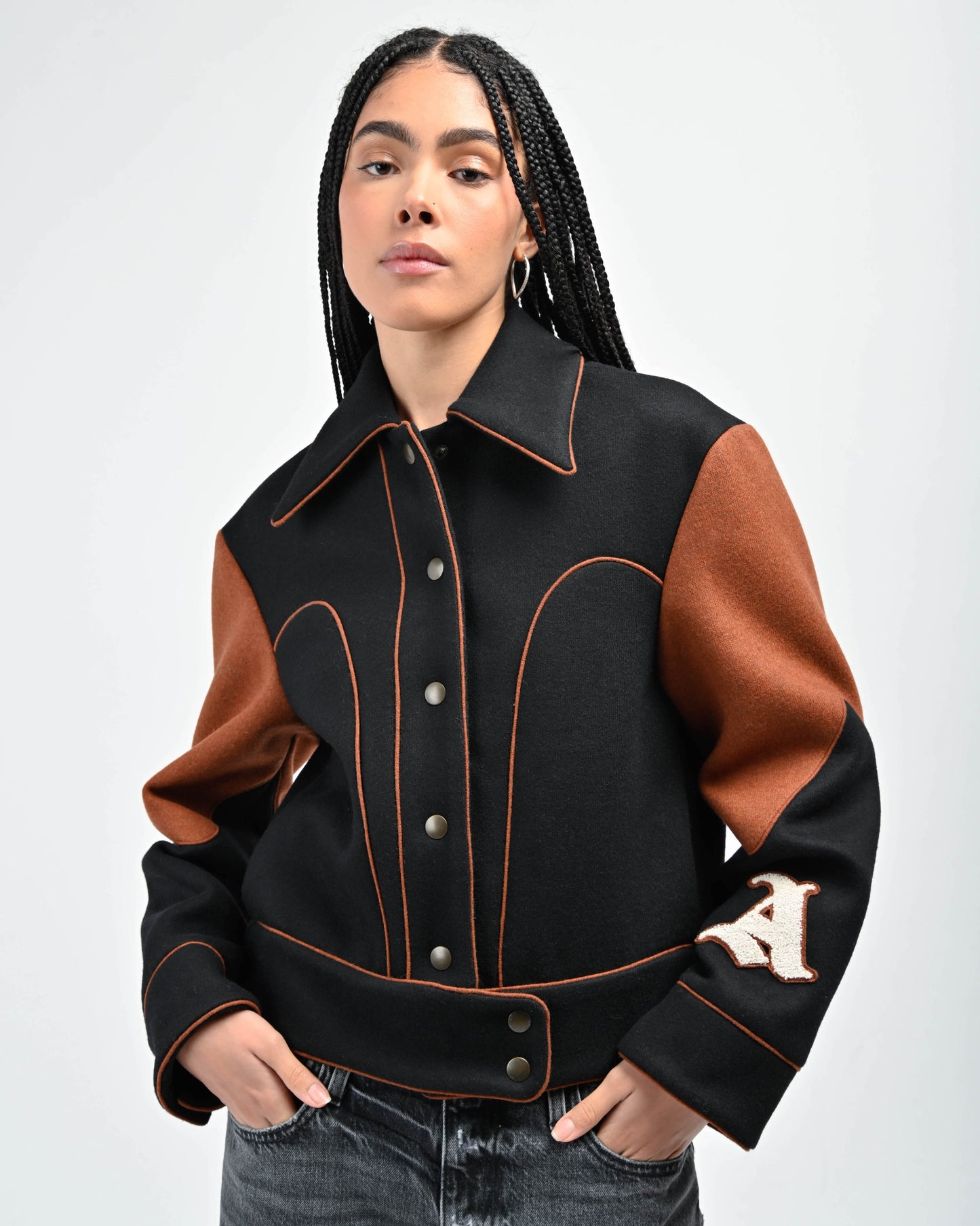 Model is wearing Rue Varsity Jacket in Black by Aseye Studio