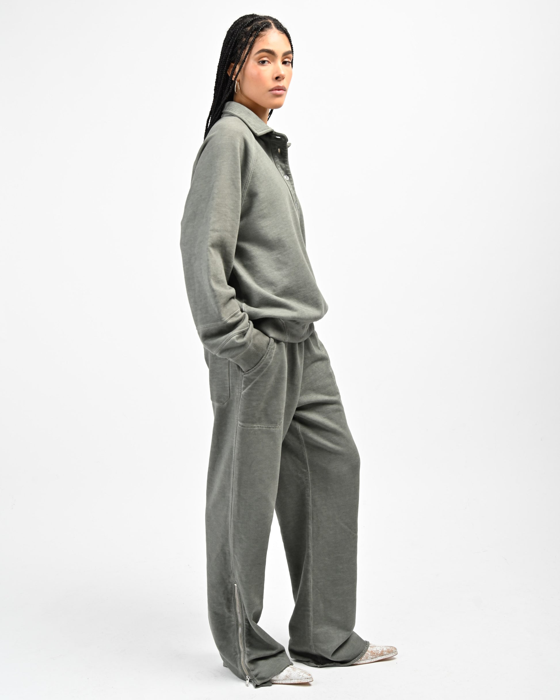Model is wearing August Pullover sweatshirt and Allora Track Pant in Muted Green by Aseye Studio