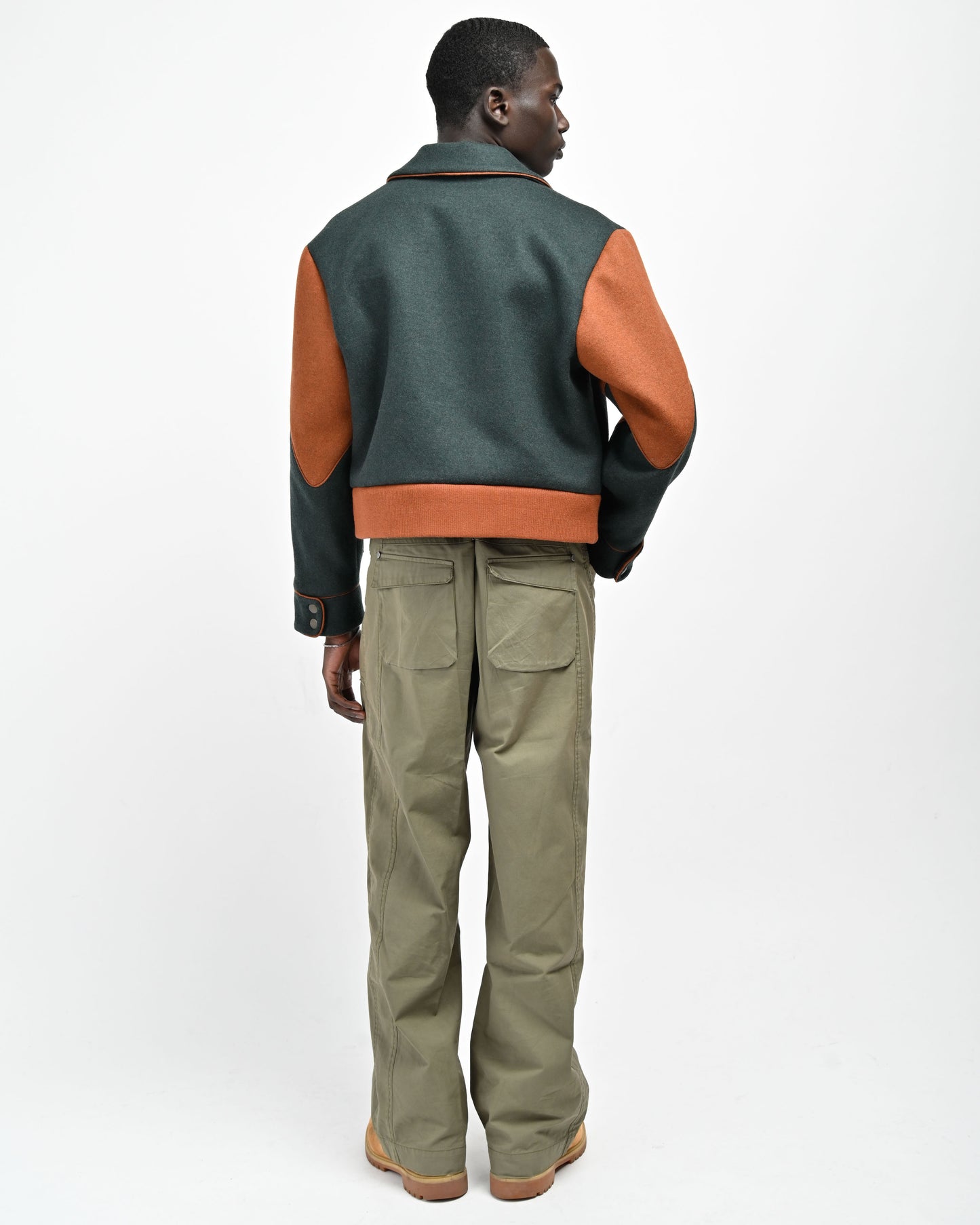 Back View of model wearing Green Rue Varsity Jacket by Aseye Studio