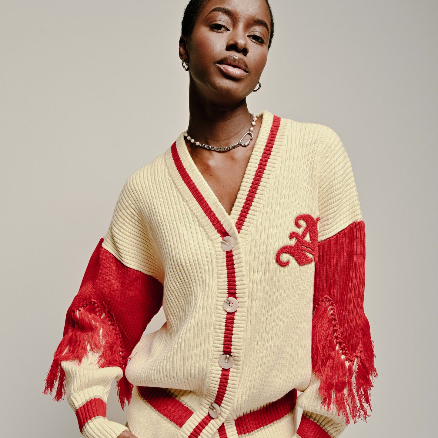 Model wearing Varsity Cardigan by Aseye Studio in Cream and Red