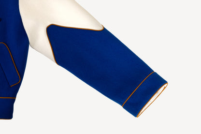 Sleeve Detail View of Liz Varsity Jacket in Royal Blue. Features Golden Yellow Contrast Suede Piping